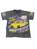A faded black graphic t-shirt featuring a yellow race car and the number 8, laid flat on a green shag rug. The shirt includes 'Turbo Overdrive' and 'High Voltage' text.