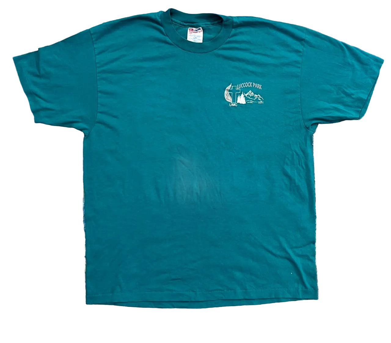 A teal short-sleeve t-shirt. The shirt features a small white graphic on the left chest depicting a lighthouse and mountains with the text 'HICOTIA PARK'.