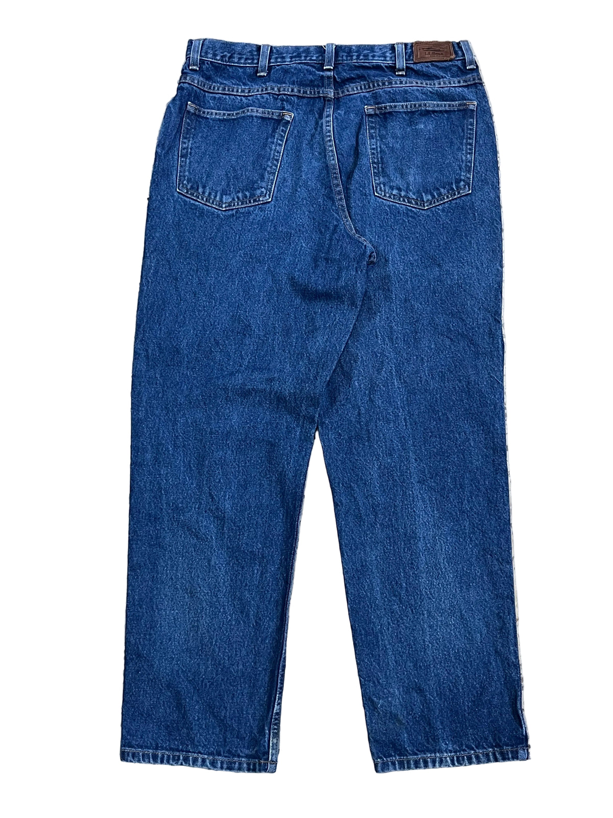 Back view of a pair of blue denim jeans ON THE WHITE BACKGROUND