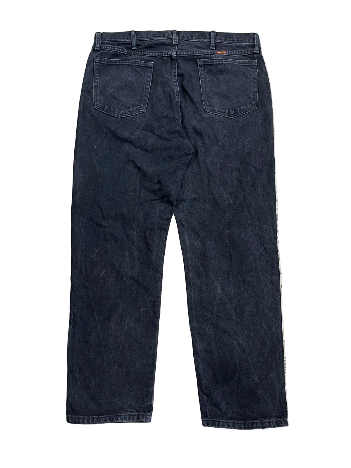 A pair of dark indigo denim jeans the back pockets and waistband.