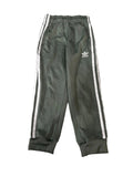 A pair of dark olive green Adidas track pants with white side stripes and a white logo on the left thigh, 