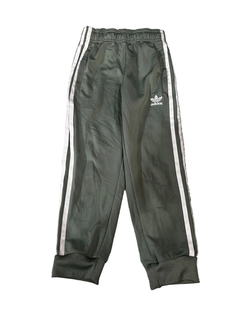 A pair of dark olive green Adidas track pants with white side stripes and a white logo on the left thigh, 