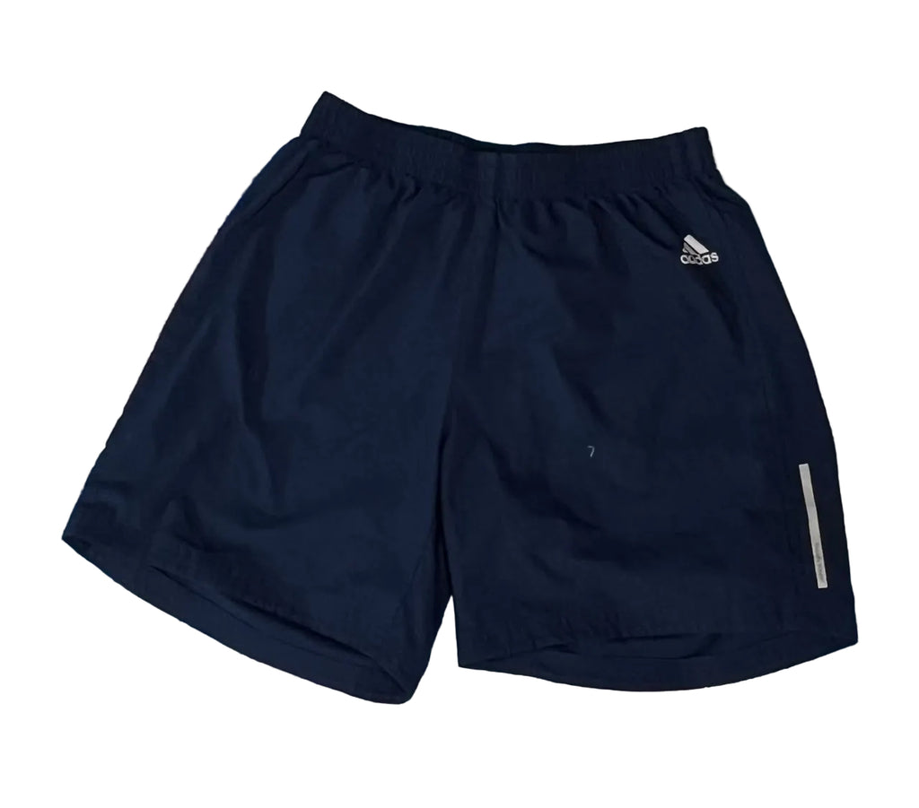 A pair of navy blue Adidas athletic shorts with a small white logo on the left hip and a reflective strip on the lower right leg,