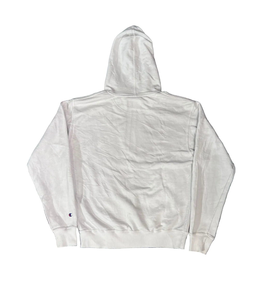 A white hooded sweatshirt The back of the hoodie is shown, featuring a small embroidered Champion 'C' logo on the left sleeve cuff.