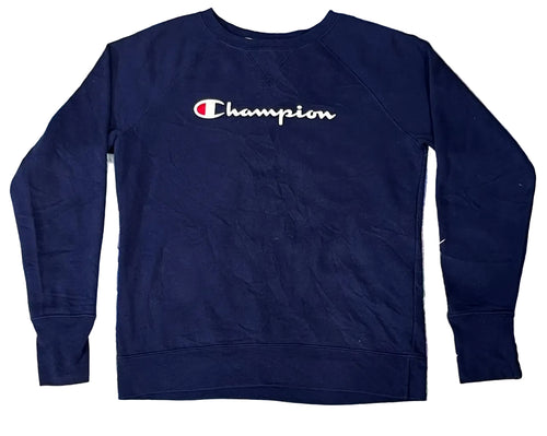 A navy blue Champion crewneck sweatshirt with the brand's signature 'C' logo and 'Champion' script across the chest, laid flat on a colorful, textured faux fur surface.