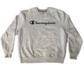 A light heather gray Champion crewneck sweatshirt with the brand name printed in black across the chest, laid flat on a textured