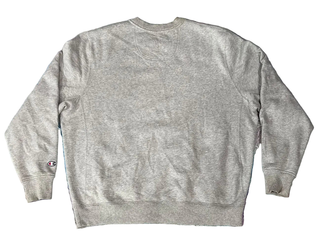 A light gray heather crewneck sweatshirt  A small Champion logo is visible on the left sleeve cuff.