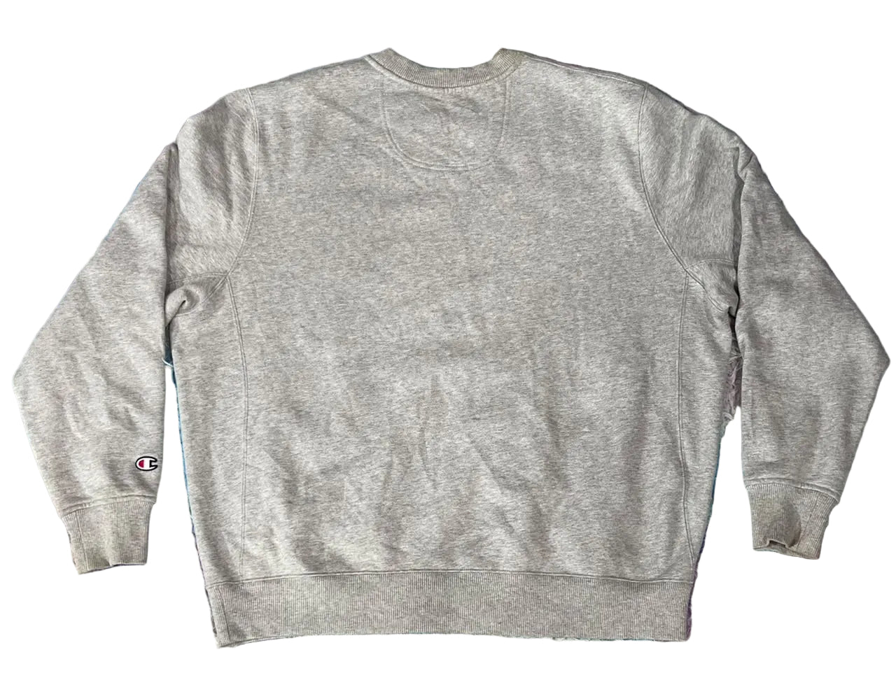 A light gray heather crewneck sweatshirt  A small Champion logo is visible on the left sleeve cuff.