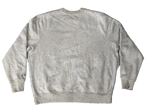 A light gray heather crewneck sweatshirt  A small Champion logo is visible on the left sleeve cuff.