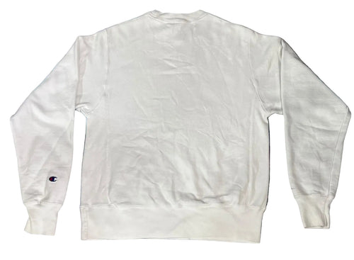 A white long-sleeve crewneck sweatshirt multicolored blue and purple rug. A small Champion 'C' logo is visible on the left sleeve cuff.