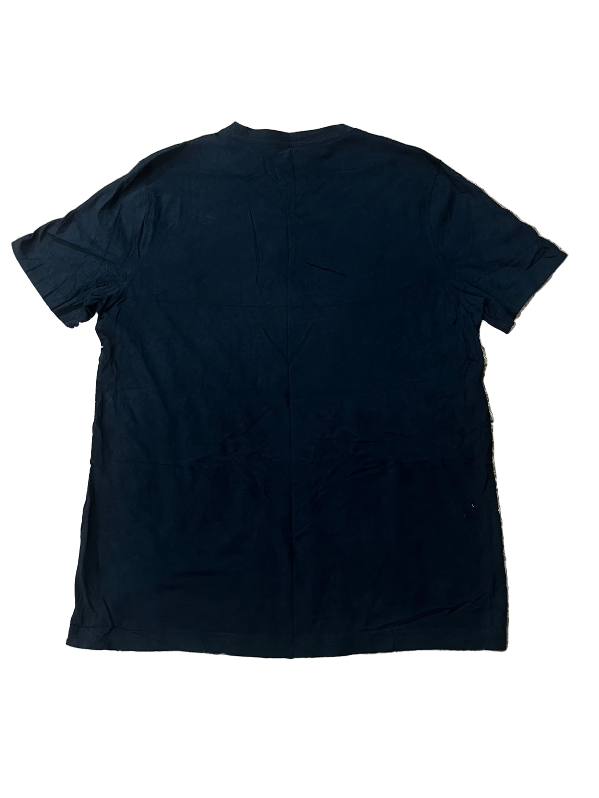 A plain black short-sleeve t-shirt laid flat on a beige shag rug.