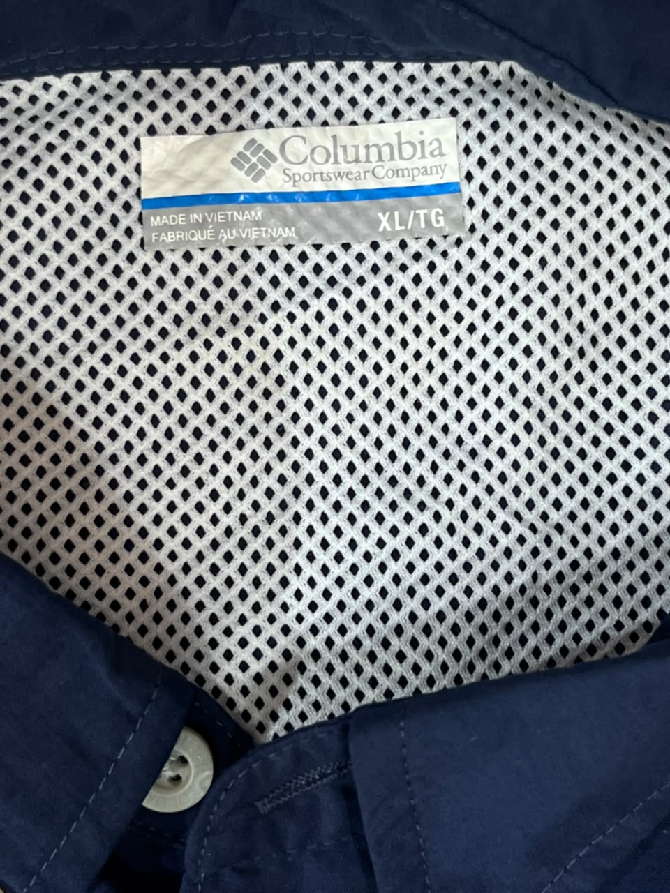 Close-up of a Columbia Sportswear shirt interior showing a navy blue collar with a white mesh lining and a visible Columbia label.