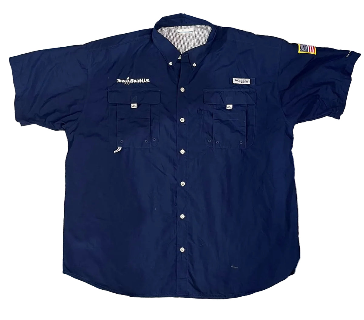 A navy blue short-sleeve button-up shirt by Columbia, . The shirt features two chest pockets, white buttons, and Columbia branding on the chest.