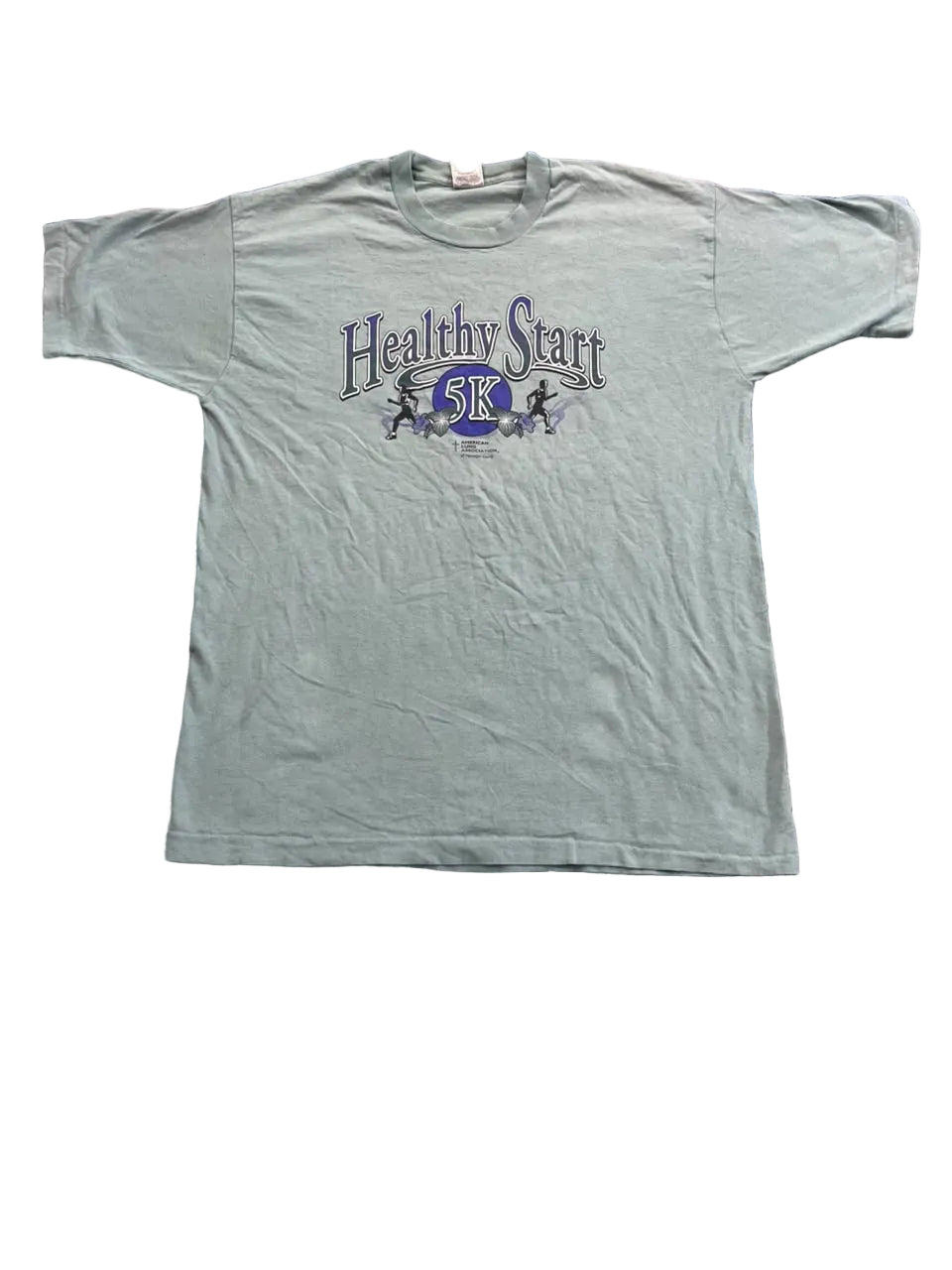 A light sage green short-sleeve t-shirt with a 'Healthy Start 5K' graphic on the chest,