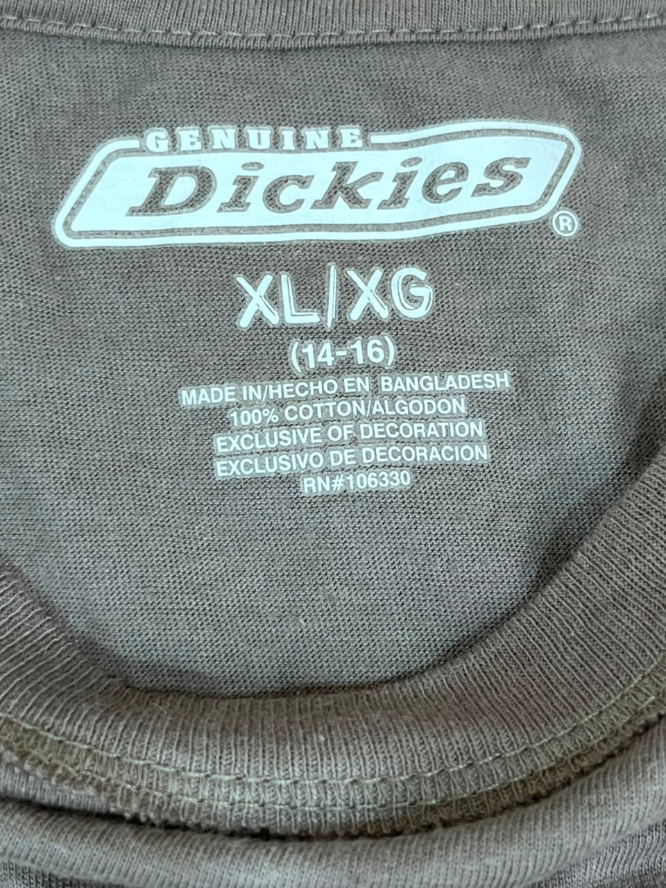 Close-up of the inside neck label of a gray Dickies t-shirt, showing the brand name 'Dickies' and size 'XL/XG'.