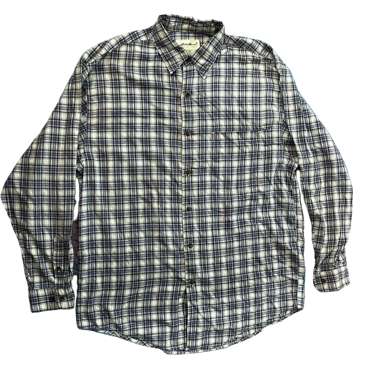 A long-sleeve button-up plaid shirt in black, white, and gray, 