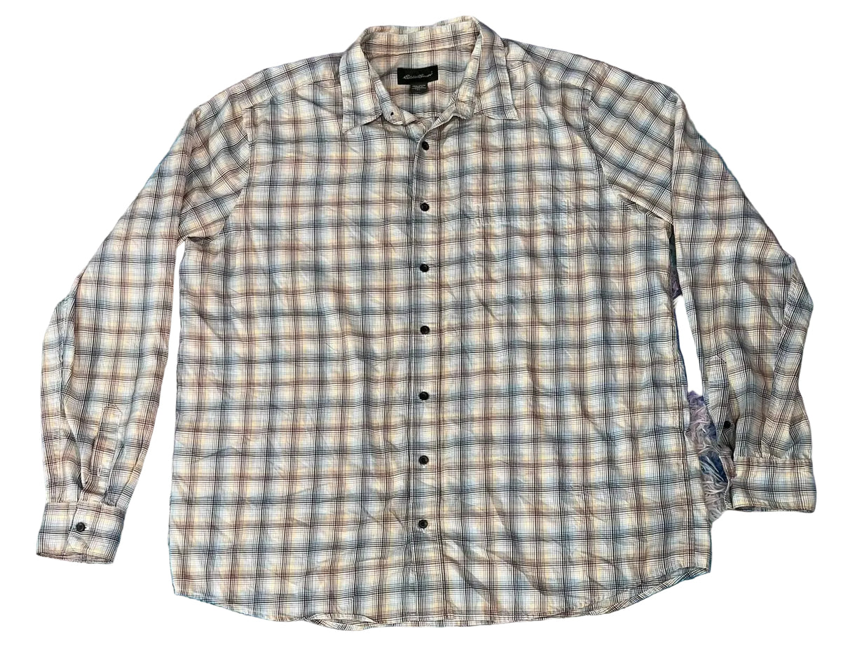 A long-sleeve plaid button-up shirt  The shirt features a beige, brown, and gray plaid pattern with black buttons.