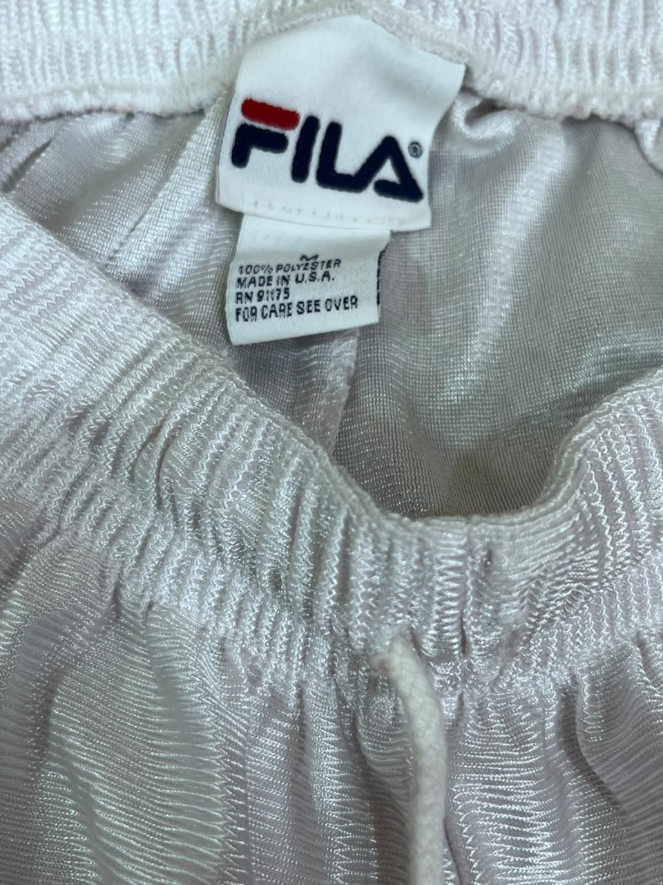 Close-up of a white FILA garment label 