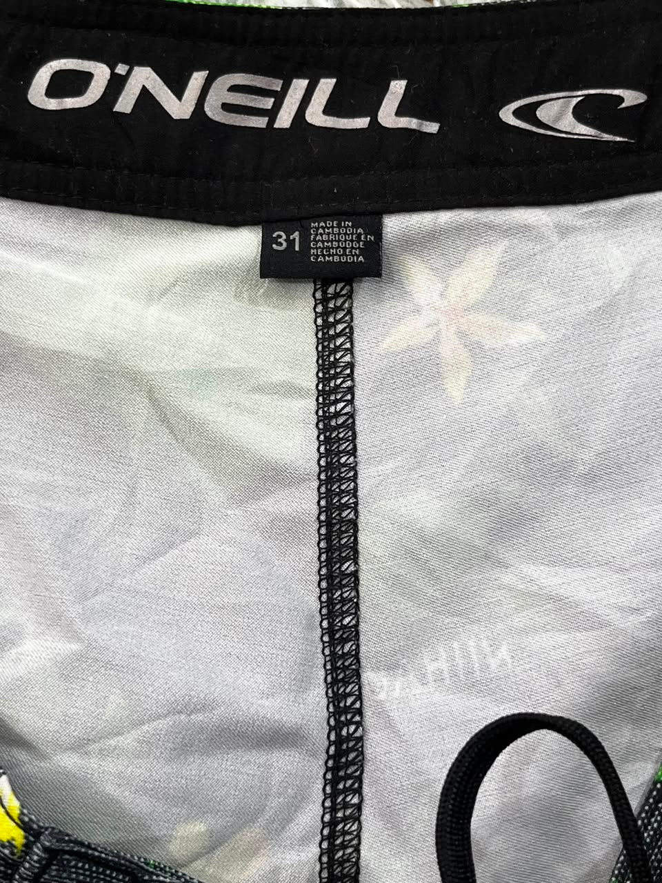 Close-up of a pair of O'Neill boxer briefs showing the black waistband with white branding, a size 31 tag, and the light gray fabric body with a subtle white floral pattern.