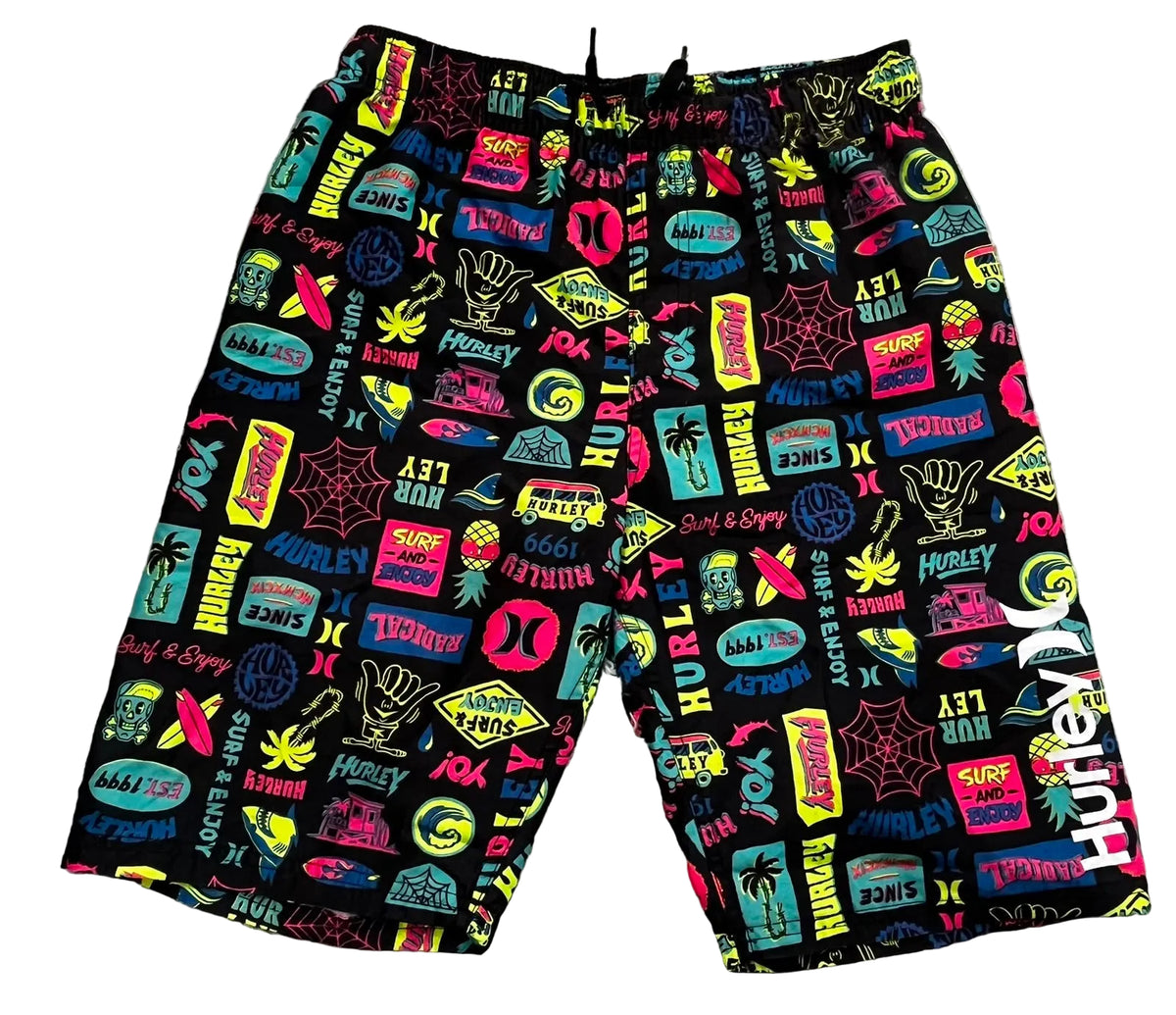 A pair of black board shorts with a vibrant, multicolor graphic print featuring the Hurley brand name, surfboards, palm trees, and web motifs, 