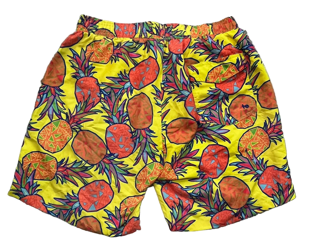 Bright yellow swim trunks with a colorful pineapple print,