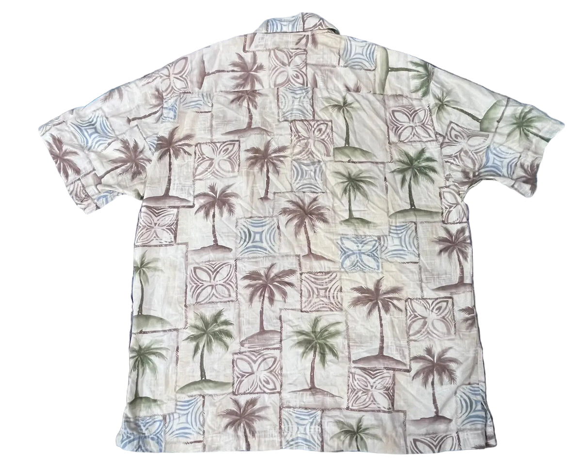 A short-sleeve button-up shirt with a tropical pattern of palm trees and geometric blocks, 