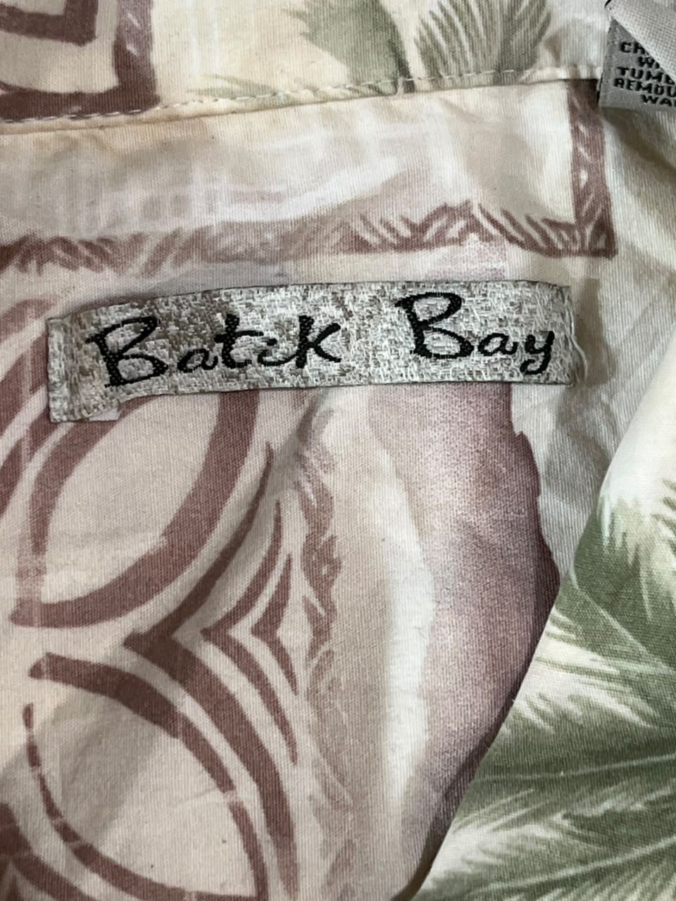 Close-up of a patterned garment with a visible Batk Bay brand label sewn onto the fabric.