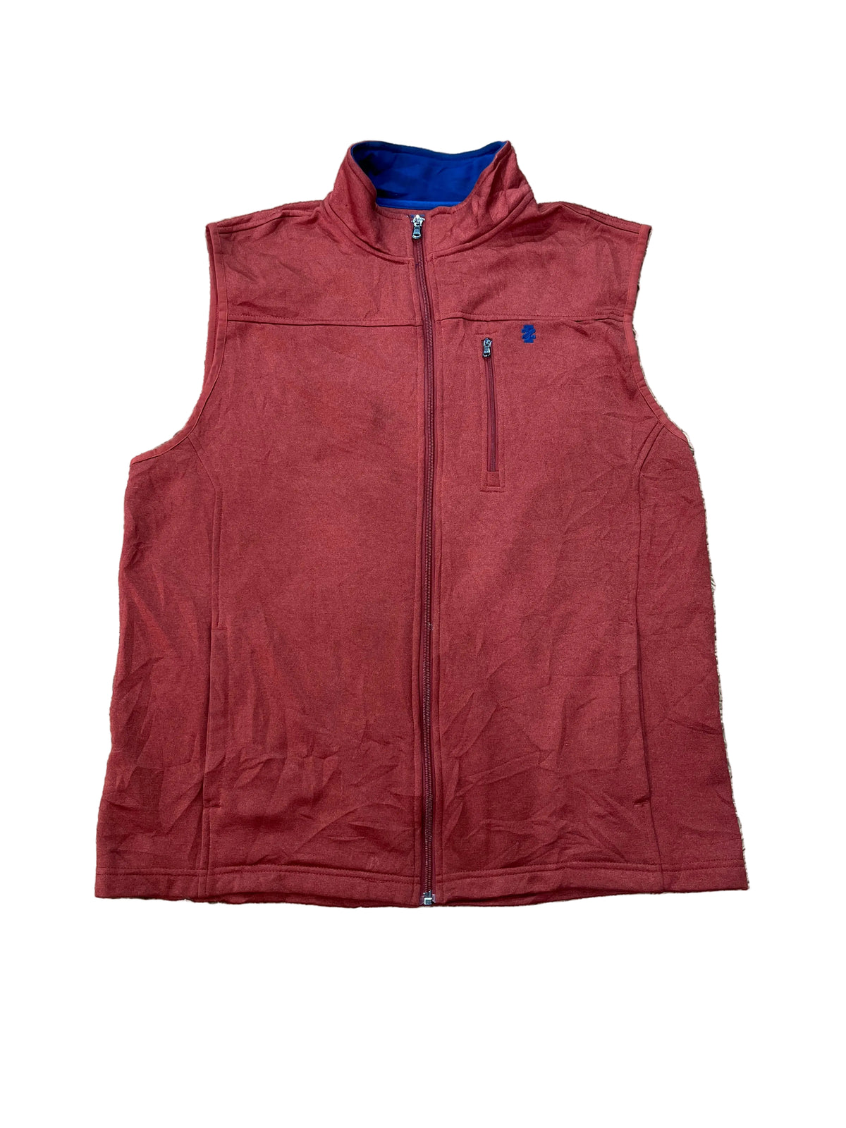 A sleeveless zip-up vest in a muted brick red color, laid flat on a beige shag rug. The vest features a blue inner collar lining and a small blue logo on the left chest pocket.