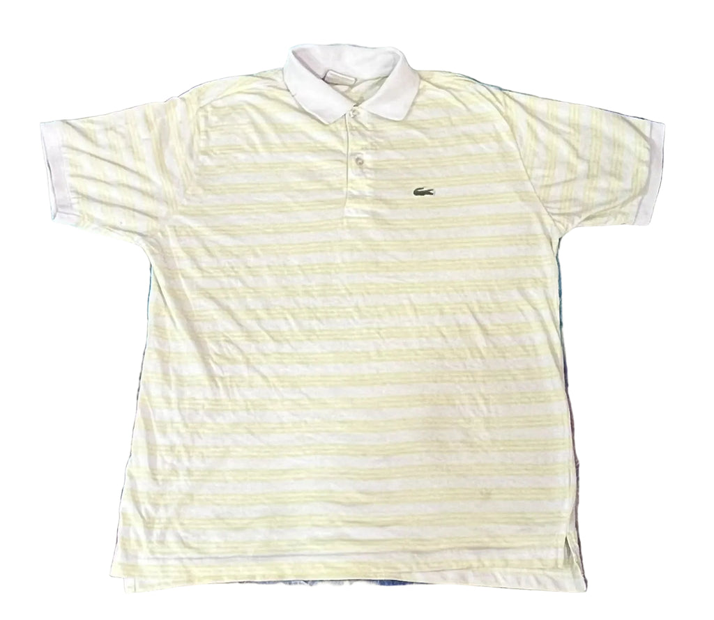 A white and pale yellow striped short-sleeve polo shirt with a white collar and a small Lacoste crocodile logo on the chest