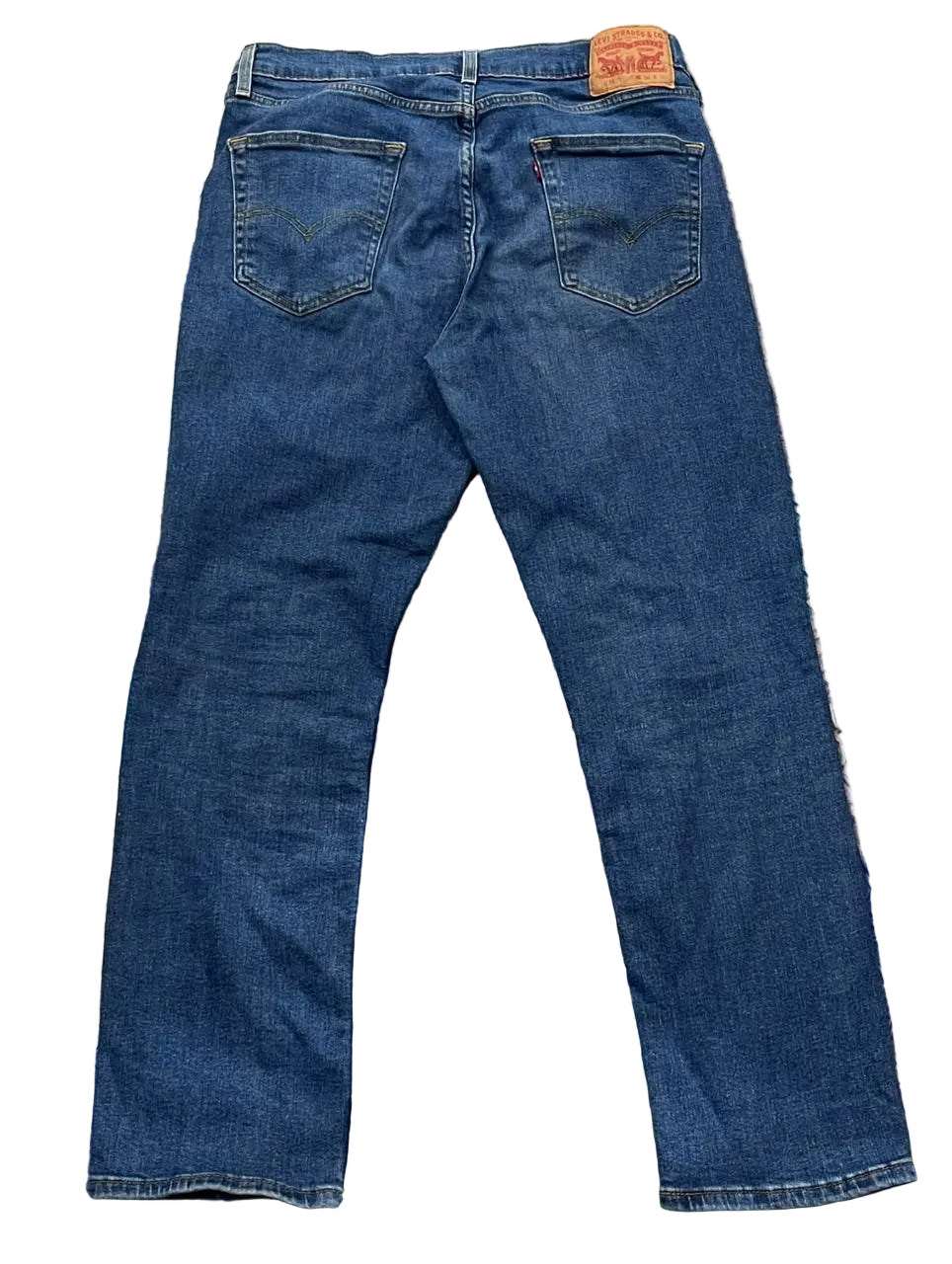 Back view of a pair of blue denim jeans . The iconic orange Levi's brand patch is visible at the back waistband.