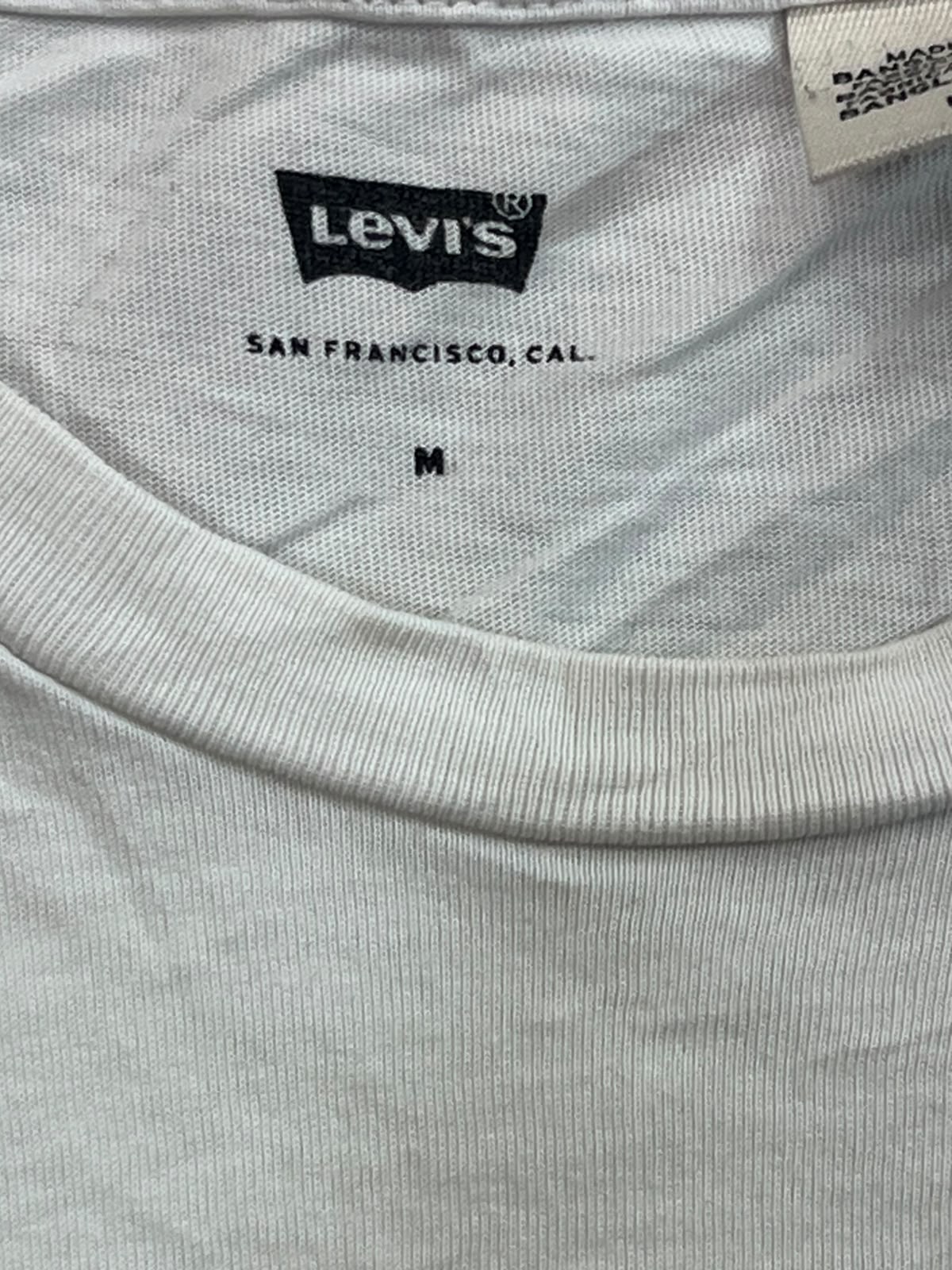 Close-up of a light gray or off-white Levi's crewneck t-shirt showing the inner neck label with 'Levi's San Francisco, Cal.' and size 'M'.