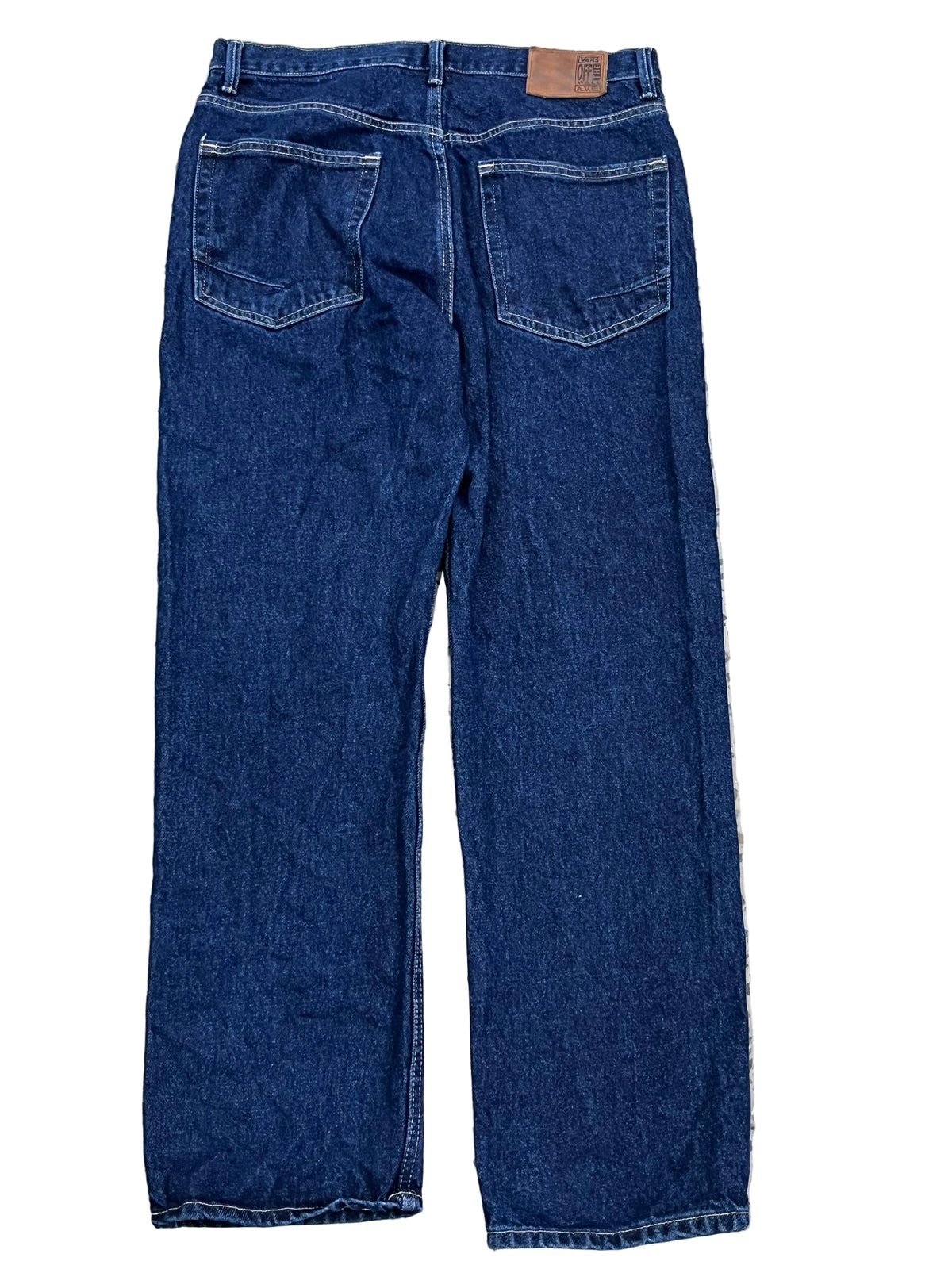 Back view of dark blue denim jeansshowing the back pockets and waistband patch.