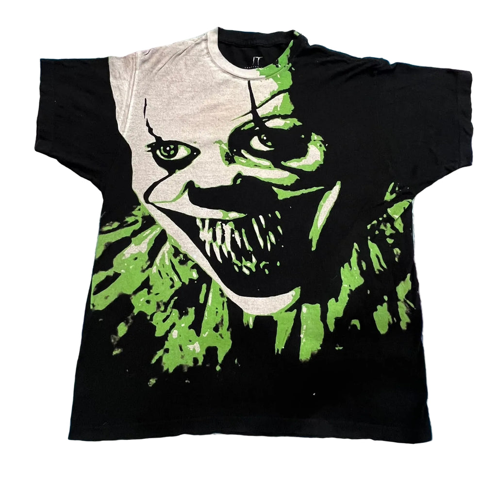 A vintage black t-shirt featuring a large graphic print of a creepy clown face with green paint splatters