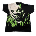 A vintage black t-shirt featuring a large graphic print of a creepy clown face with green paint splatters