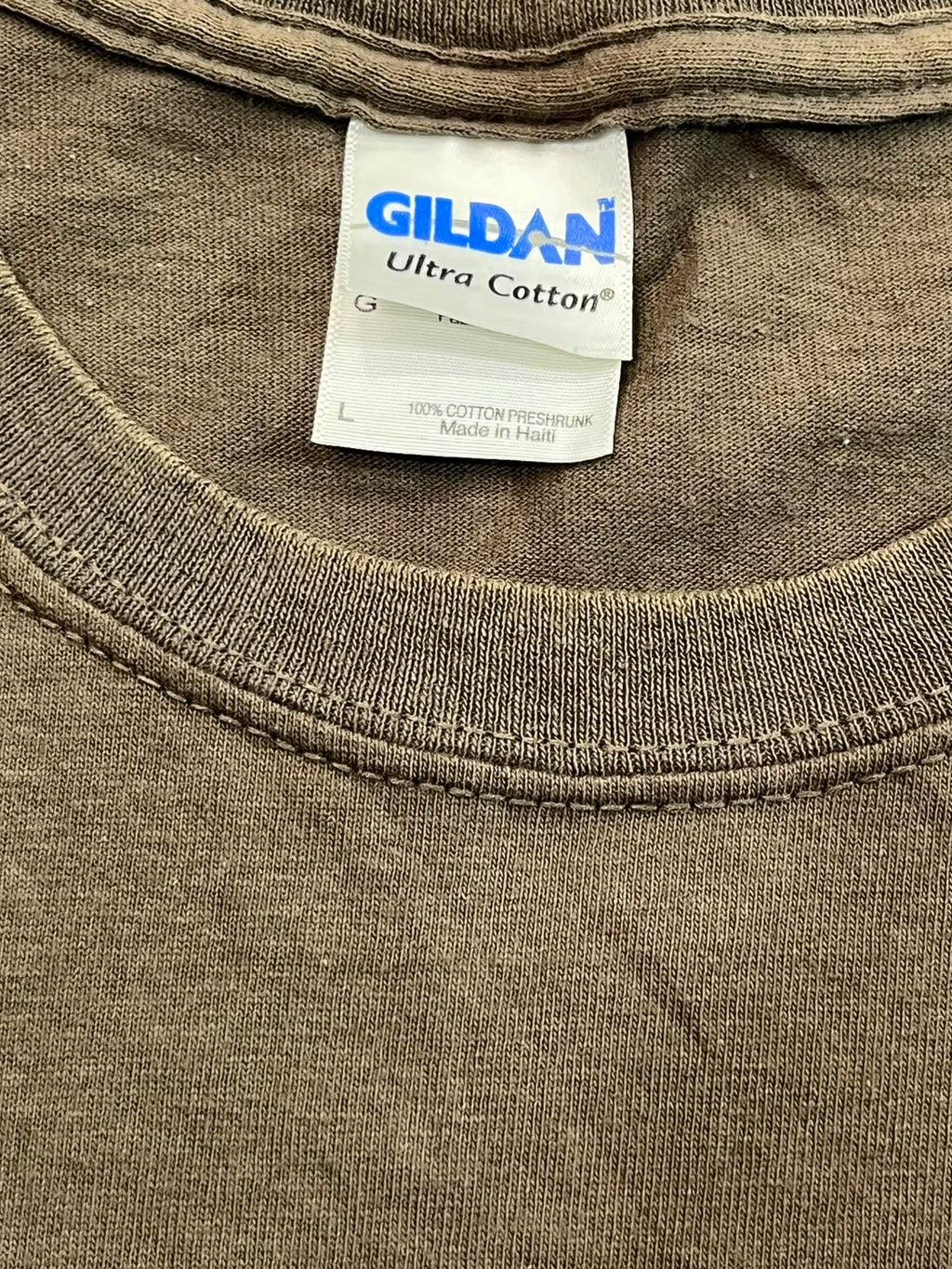 Close-up of a Gildan Ultra Cotton t-shirt neck label and ribbed collar in a muted brownish-gray color.