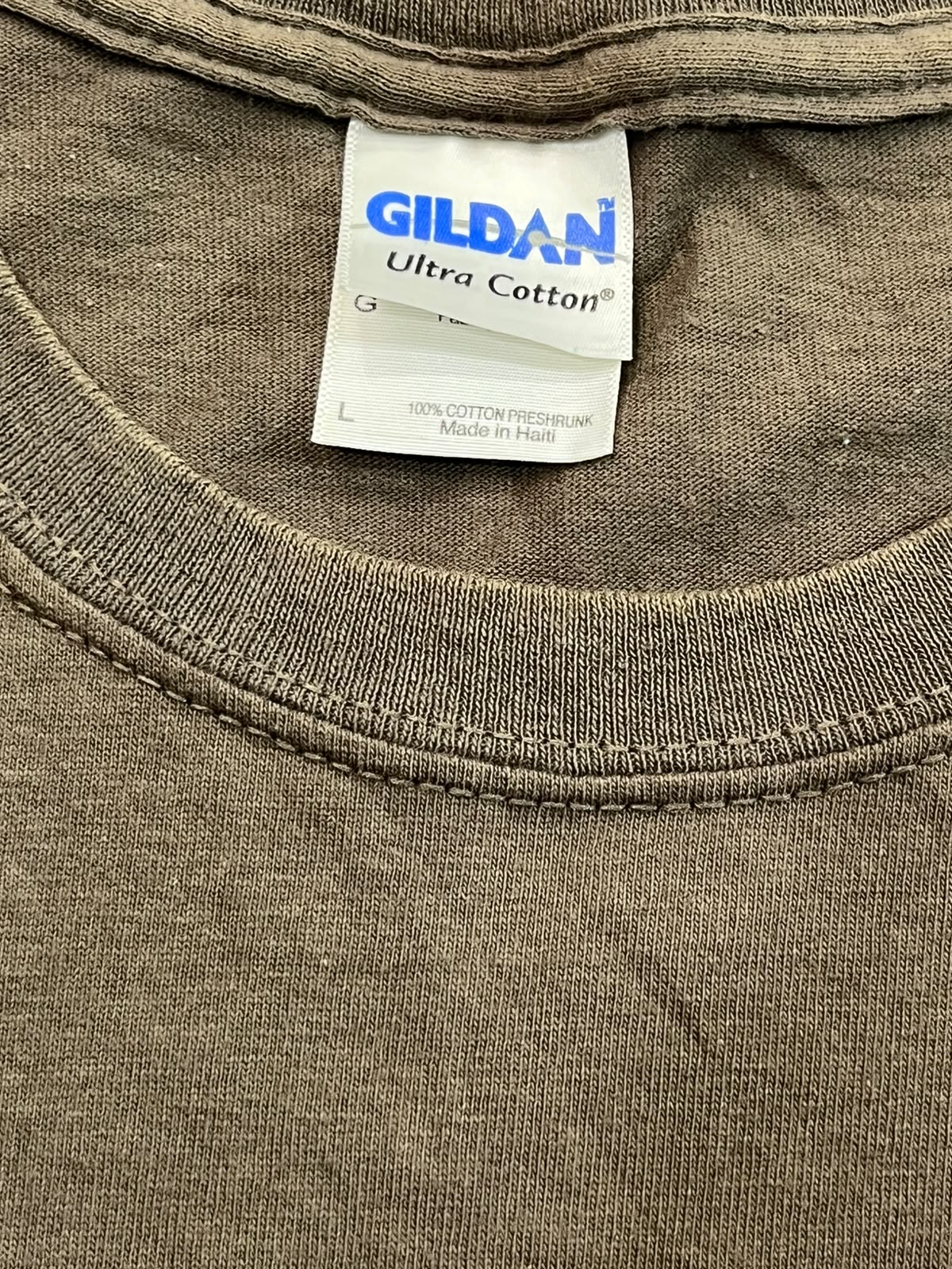 Close-up of a Gildan Ultra Cotton t-shirt neck label and ribbed collar in a muted brownish-gray color.