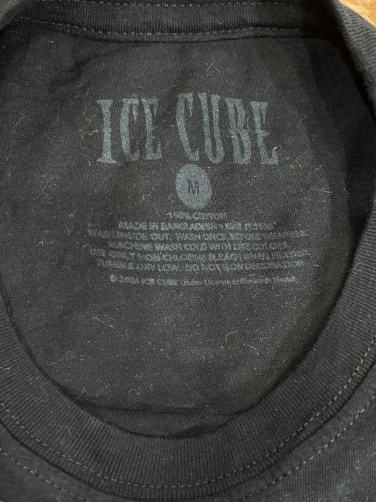 Close-up of the inside collar of a black Ice Cube t-shirt, showing the printed gray brand logo and care instructions on the inner neck label.