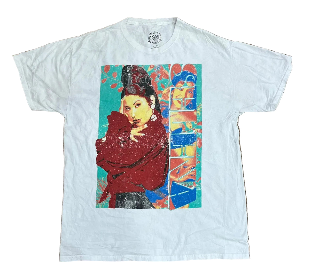 A white short-sleeve graphic t-shirt  The shirt features a large, colorful pop-art style print on the front depicting a woman in a red top against a teal and blue background.
