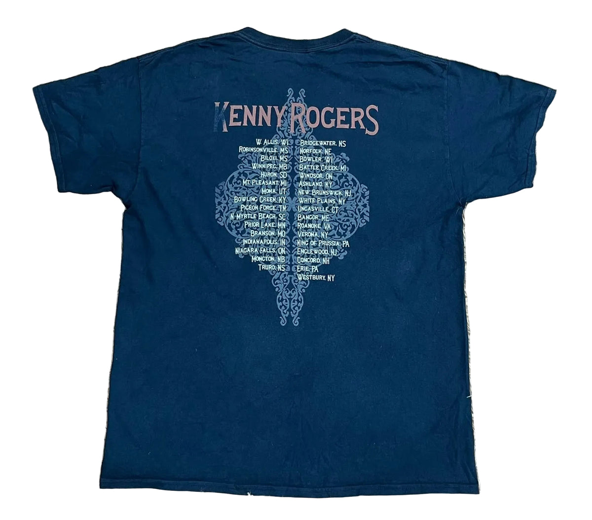 A navy blue short-sleeve Kenny Rogers t-shirt showing the back with a large light blue graphic and pink 'KENNY ROGERS' text.