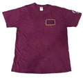 A maroon short-sleeve t-shirt with a gold-outlined '2015' patch on the left chest,