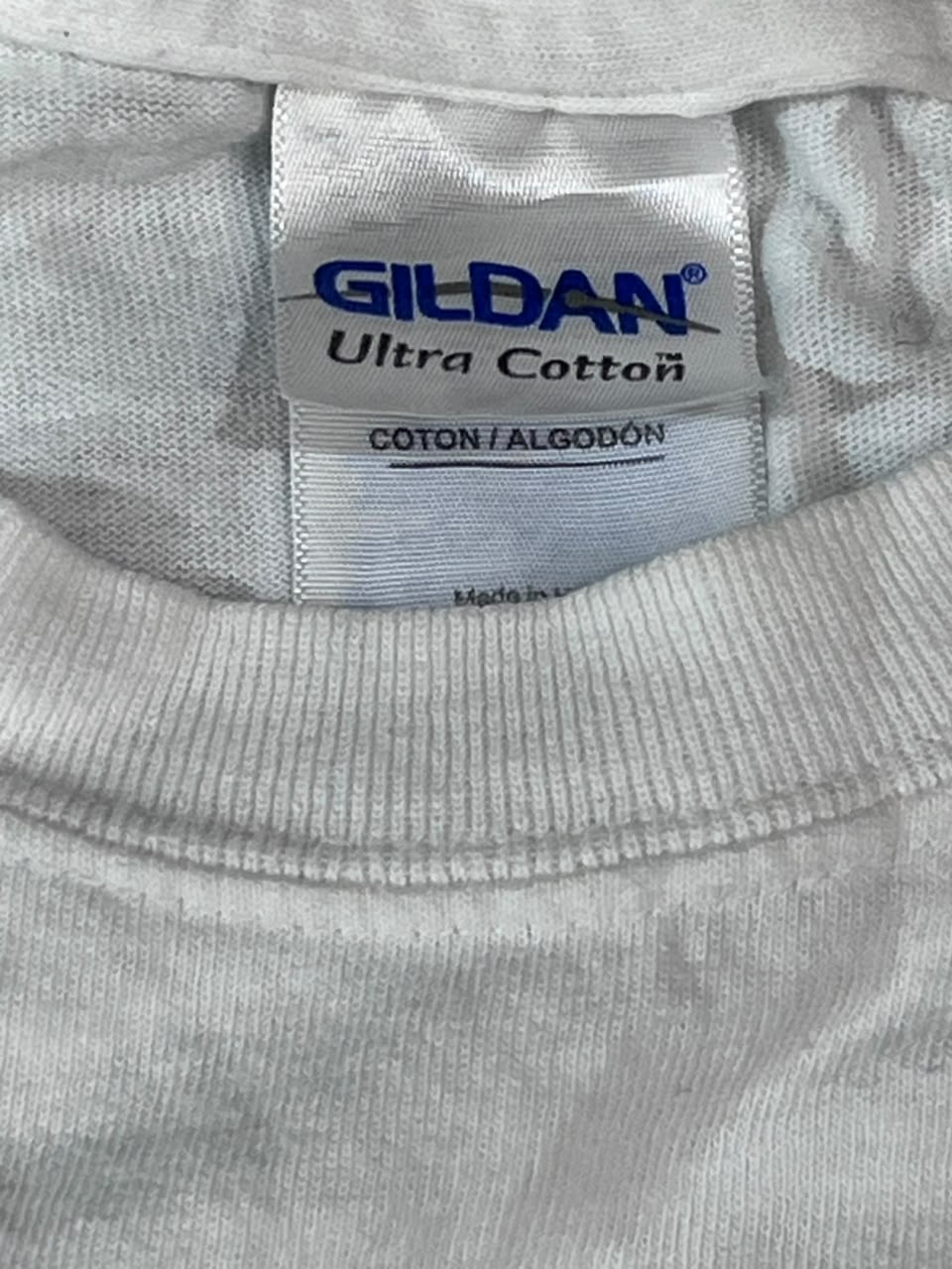 Close-up of a Gildan Ultra Cotton t-shirt neck label, showing the brand name in blue and the white ribbed collar of the garment.