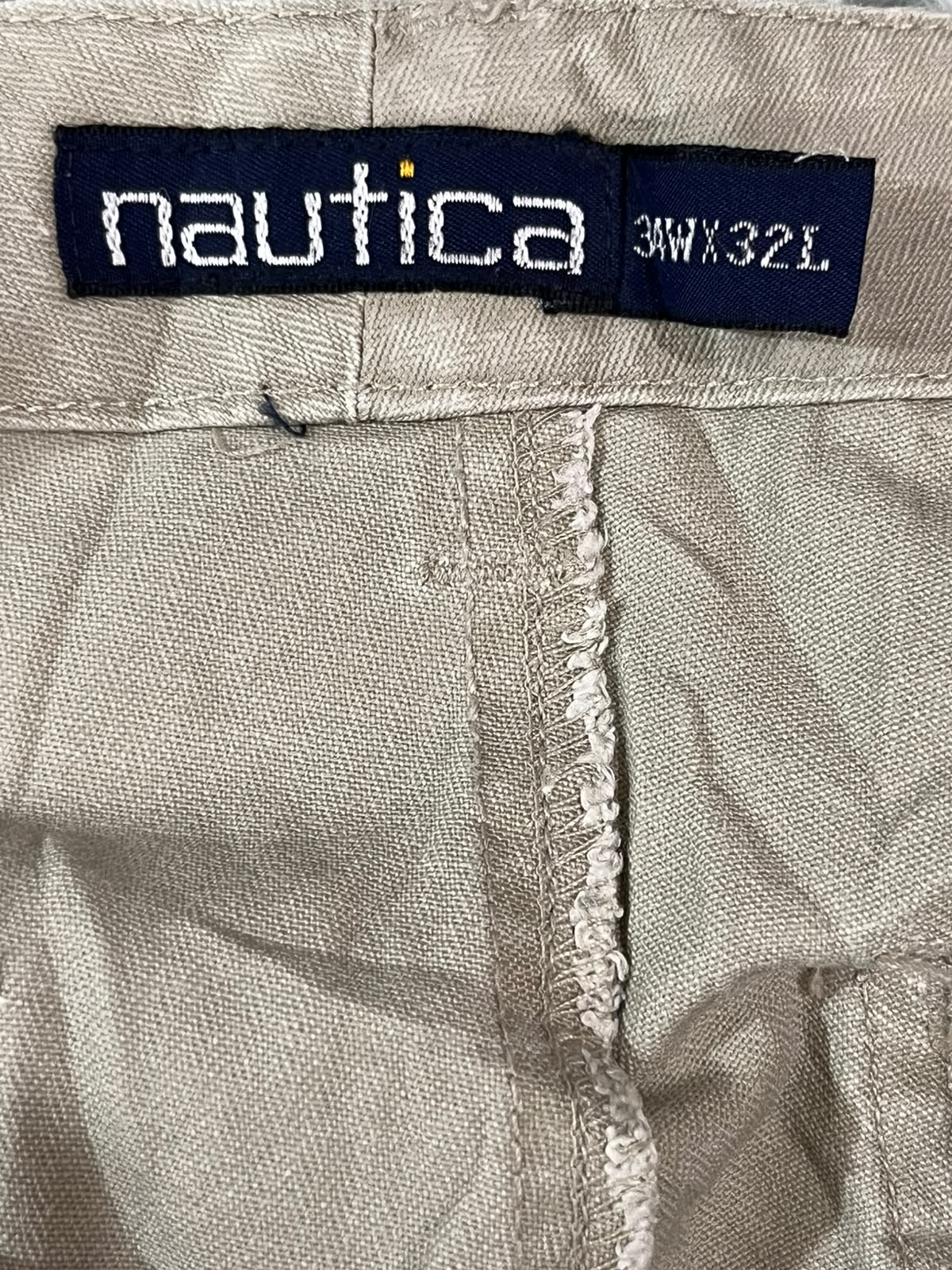 Close-up of a beige woven fabric garment showing a navy blue Nautica brand label sewn into the waistband, with size text reading 3WX32L.