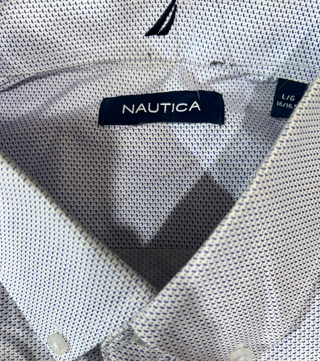 Close-up of a Nautica polo shirt collar showing the navy brand label and the small size tag on a white textured fabric.