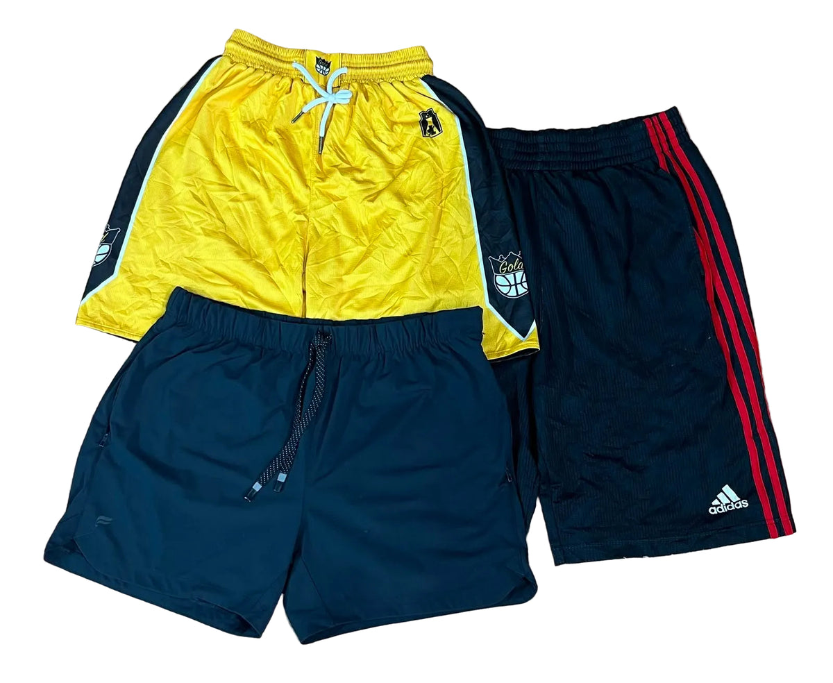 Three pairs of athletic shorts  a bright yellow pair with navy side panels and white drawstring, a navy pair with red side stripes and white Adidas logo, and a navy pair with a small crest patch.