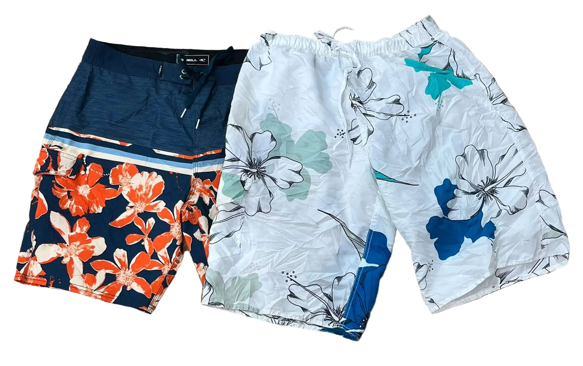 Two pairs of men's swim trunks One pair is dark navy with a bright orange and white floral print, and the other is white with a floral print in blue, green, and gray.