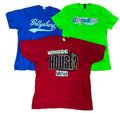 Three vintage graphic t-shirts in blue, green, and red, The blue shirt features 'Sellysburg' in white script, the green shirt has 'donut SK' with a rainbow graphic, and the red shirt displays 'WHOSE HOUSE?' in black and leopard print with a 'Savages House' logo below.