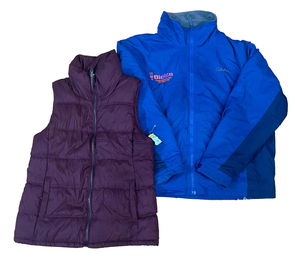 Two children's winter jackets: a sleeveless quilted puffer vest in dark plum purple on the left, and a blue zip-front jacket with darker blue panels on the sleeves on the right. The blue jacket has a visible 'Columbia' logo on the chest.