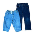 Two pairs of children's jeans one light blue denim pair with an elastic waistband and one dark blue denim pair with a button fly.