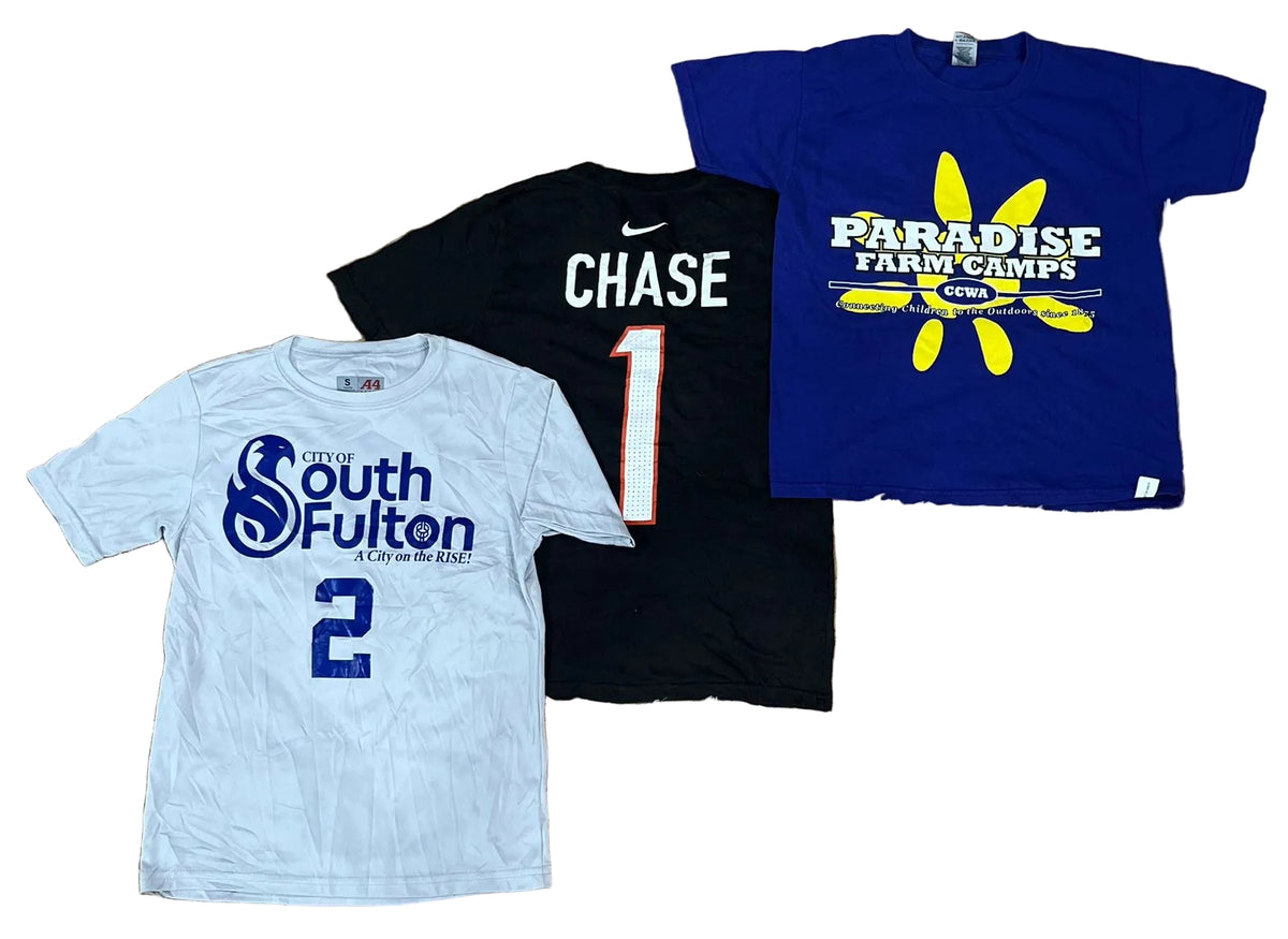 Three graphic t-shirts a light gray shirt with blue 'South Fulton' text and number 2, a black shirt with 'CHASE 1' in white and red, and a royal blue shirt with a yellow sun graphic and 'Paradise Farm Camps' text.