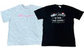 Two short-sleeve t-shirts a light heather gray Champion t-shirt with a pink Champion logo on the chest, and a black t-shirt with a white holiday graphic reading 'Most Likely to belt out carols' with a Santa hat and string lights.
